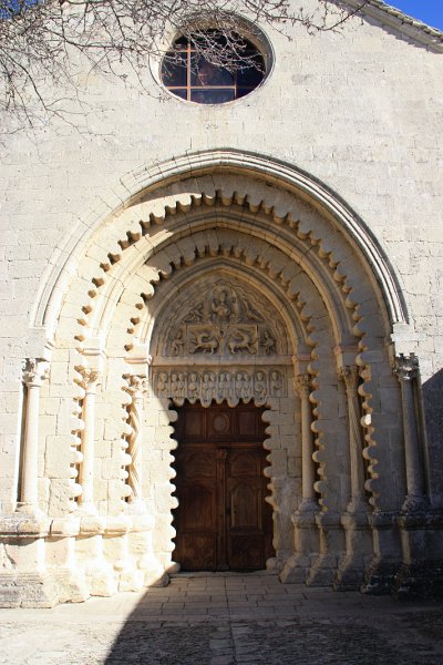 IMG_5365.JPG - La façade occidentale de l'église est la partie la plus remarquable. Le portail est la première des splendeurs du prieuré de Gangobie que l'on peut voir lorsquel'on entre dans l'eglise romane. Sous un oculus de grand diamètre se trouve un portail monumental assez profond et établi dans l'épaisseur du mur-pignon.Ayant subi plusieurs restauration vers le XVIe ou plus surement vers le XVIIe siècle, il se compose d'une archivolte où les voussures pleines sont associées à des voussures festonnées retombant sur des colonnettes de chaque côté, et prennant appui sur un bahut constitué de cinq socles moulurés.Ces colonnettes sont rehaussées de chapiteaux corinthiens à feuilles d'acanthe, tous différents.L'un represente un masque d'homme barbu, l'autre des masques de gladiateurs grimacants ;des diablotins semblent surgir de la pierre...